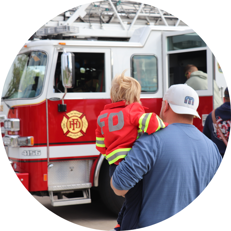 dad and son looking at fire truck
